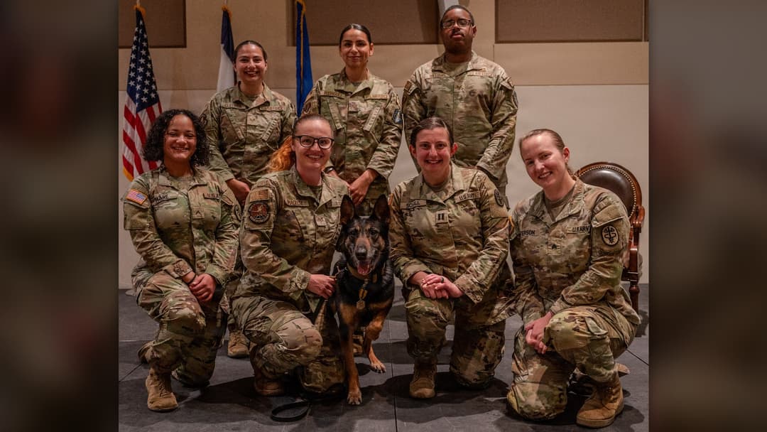 Handlers and veterinary staff posing with retiring military working dog Sego at Buckley Space Force Base.